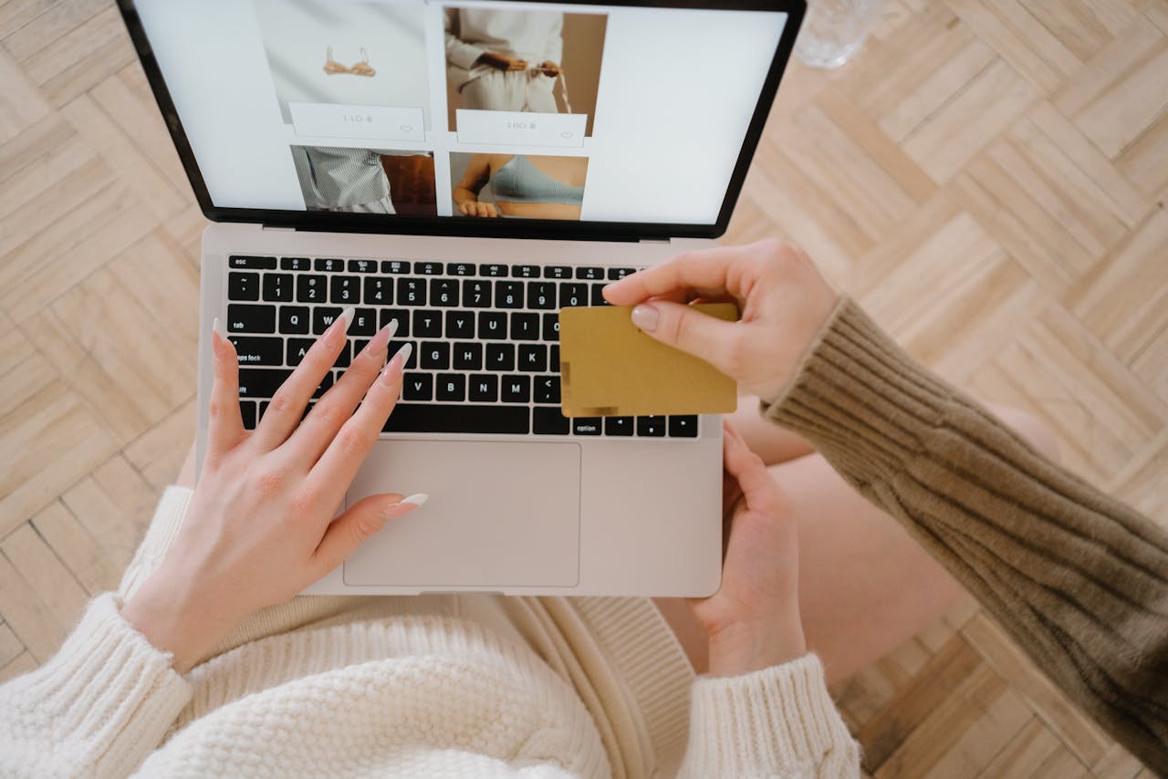 trusted-partner Person shopping online using a laptop and credit card, highlighting e-commerce convenience.